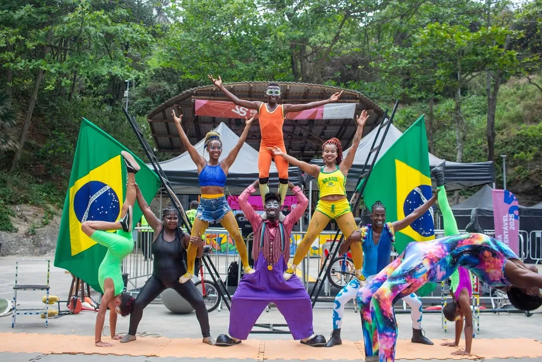 Grupo de artistas circenses em apresentação coletiva ao ar livre